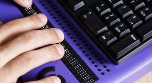 Person nutzt Braille-Zeile von Computer-Tastatur