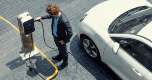 Businessman lädt E-Auto auf