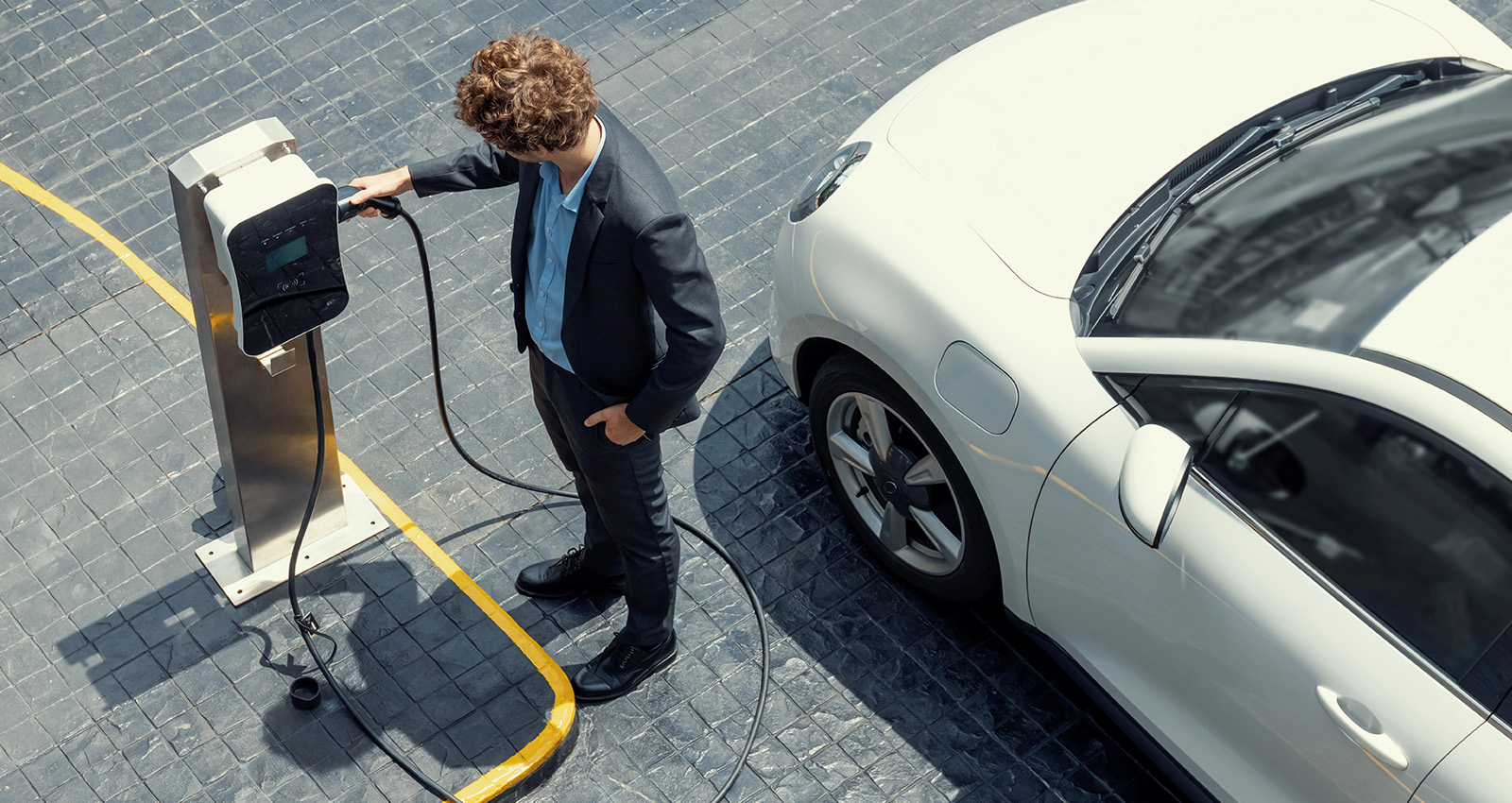 Businessman lädt E-Auto auf