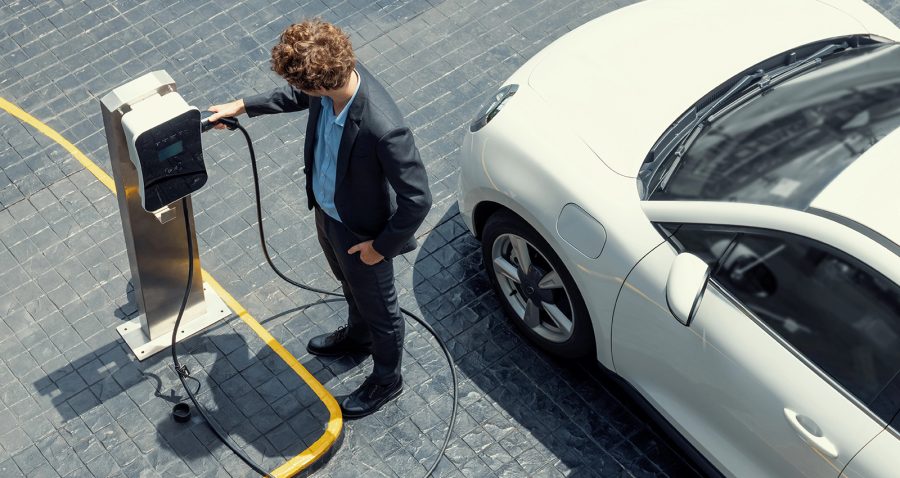 Businessman lädt E-Auto auf