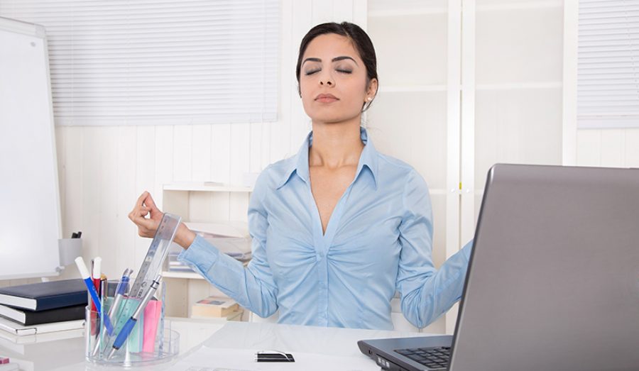 Attractive secretary with closed eyes is doing meditation at off