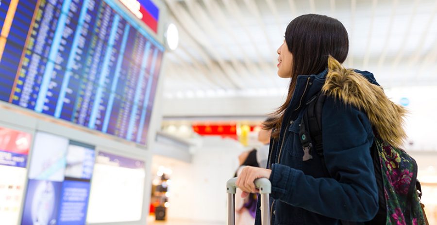 Woman looking at information board and checking her flight